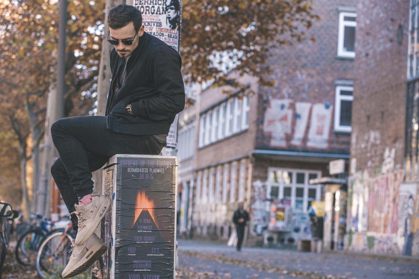 Ein Mann sitze auf einem Kasten mit werbe Plakaten